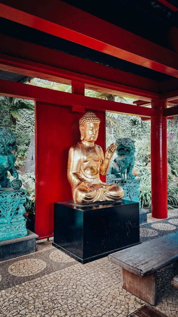 Eine goldene Buddha-Statue in einer der Pagoden im orientalischen Garten des Monte Palace, flankiert von bronzenen Wächterlöwen. Foto: Ewelina Podrez-Siama 2025