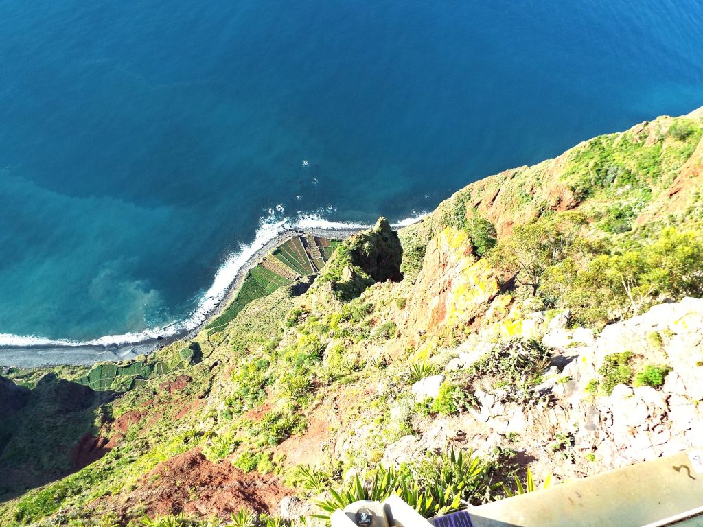 Blick von der Plattform am Cabo Girão senkrecht hinunter auf die Felder der Fajã und den Ozean