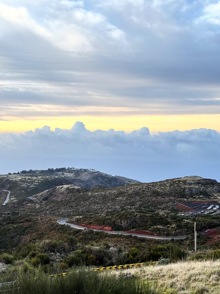 Die kurvige Straße zum Pico do Arieiro über die Hochebene, dahinter ein Wolkenmeer