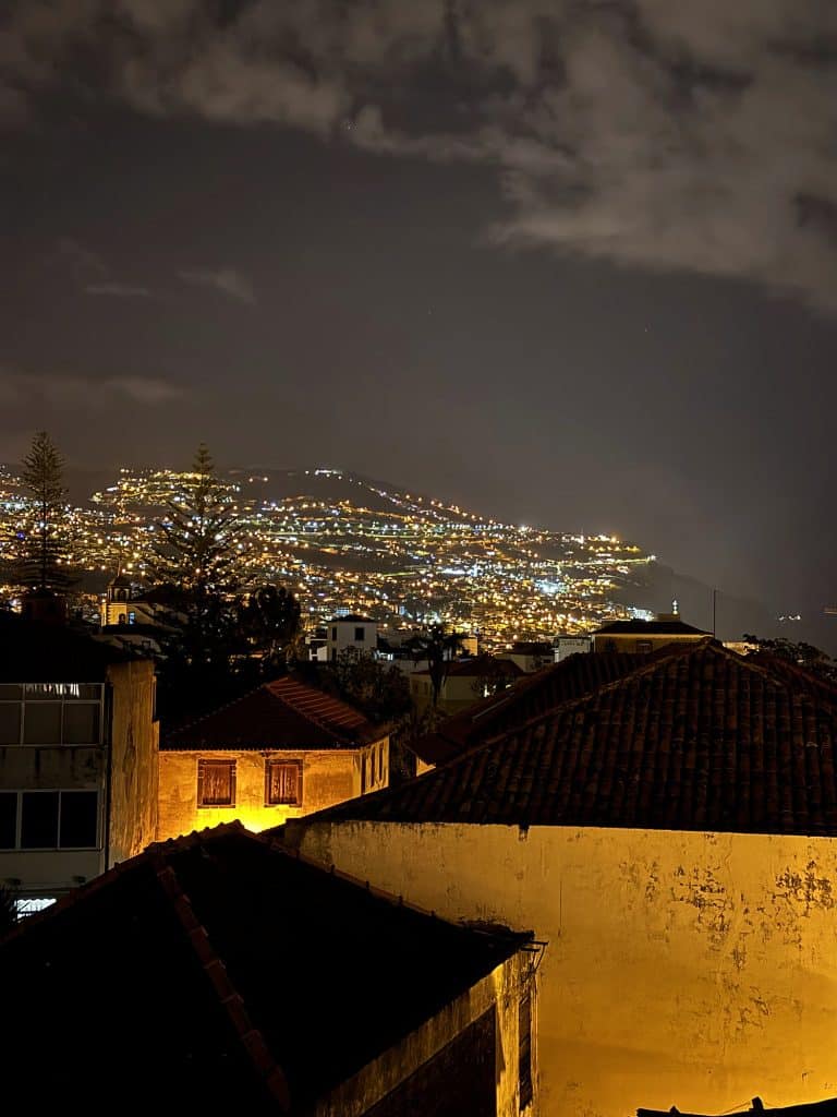 Die Lichter von Funchal bei Nacht, von einer Terrasse über den Dächern aus gesehen