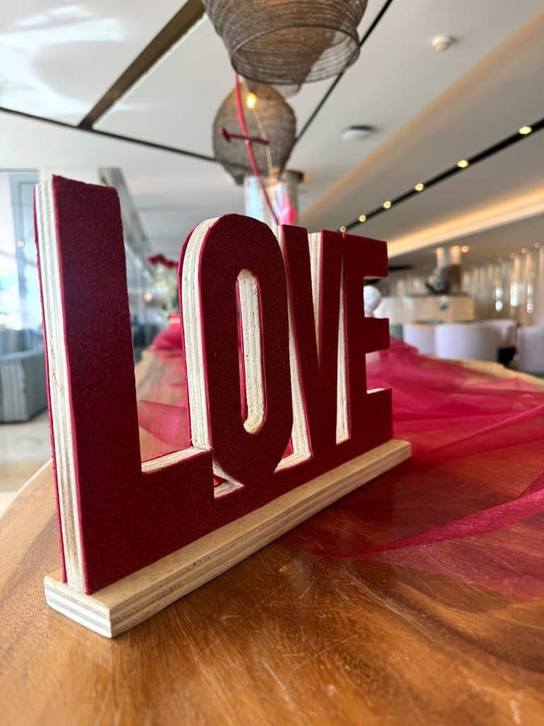 Roter LOVE-Schriftzug auf einer Holztheke in der Hotellobby