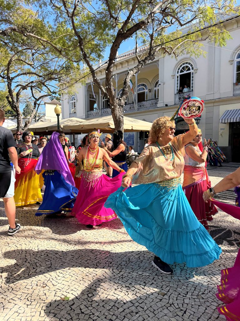 Tänzerinnen in bunten Röcken beim Carnaval Solidário auf der Avenida Arriaga in Funchal