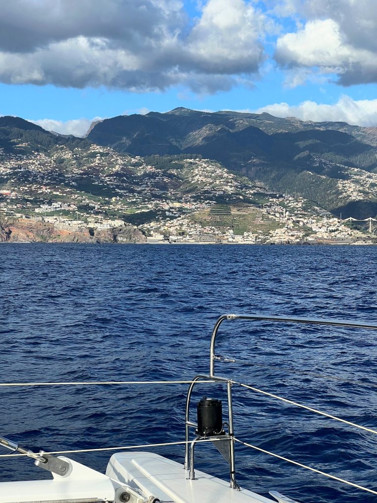 Bug eines Katamarans mit Reling und Blick vom Meer auf Funchal