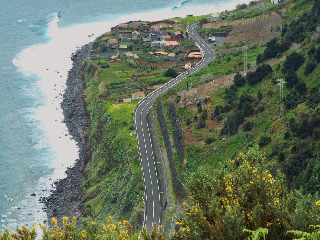 Kurvige Straße zwischen Feldern über dem Ozean an der Nordküste Madeiras