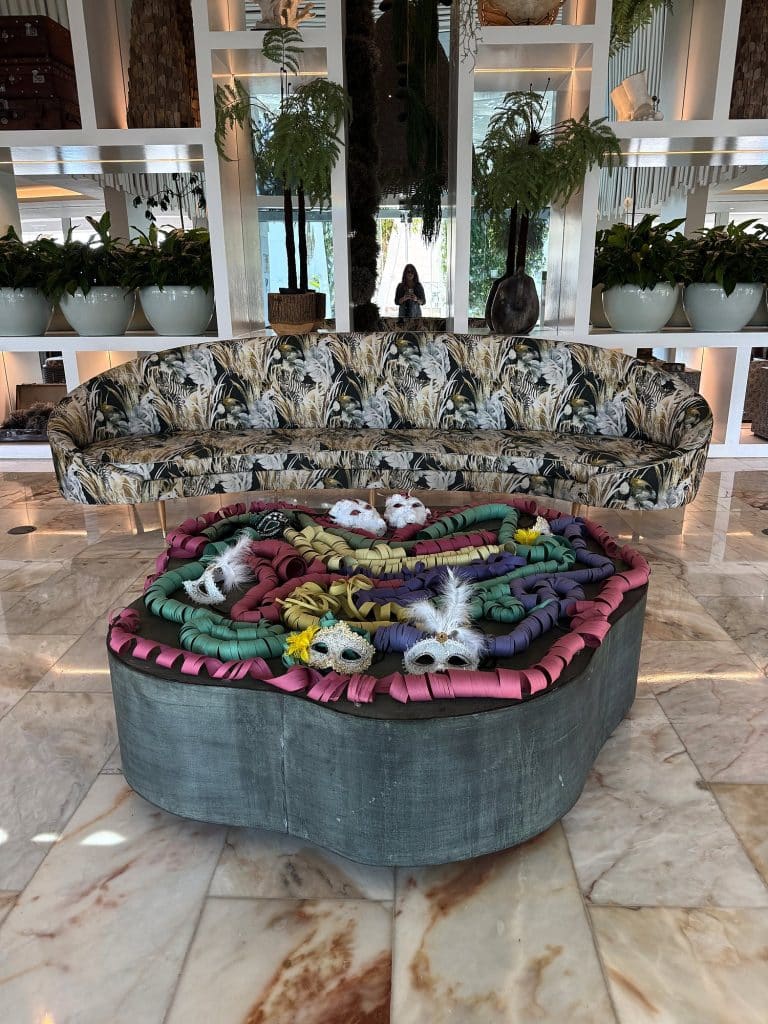 Bunte Karnevalsmasken auf einem runden Tisch in einer Hotellobby