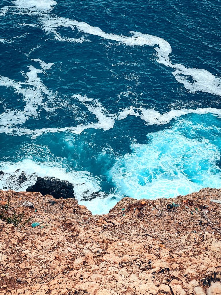 Türkiser Ozean bricht sich an den Felsen unter den Klippen der Ponta de São Lourenço
