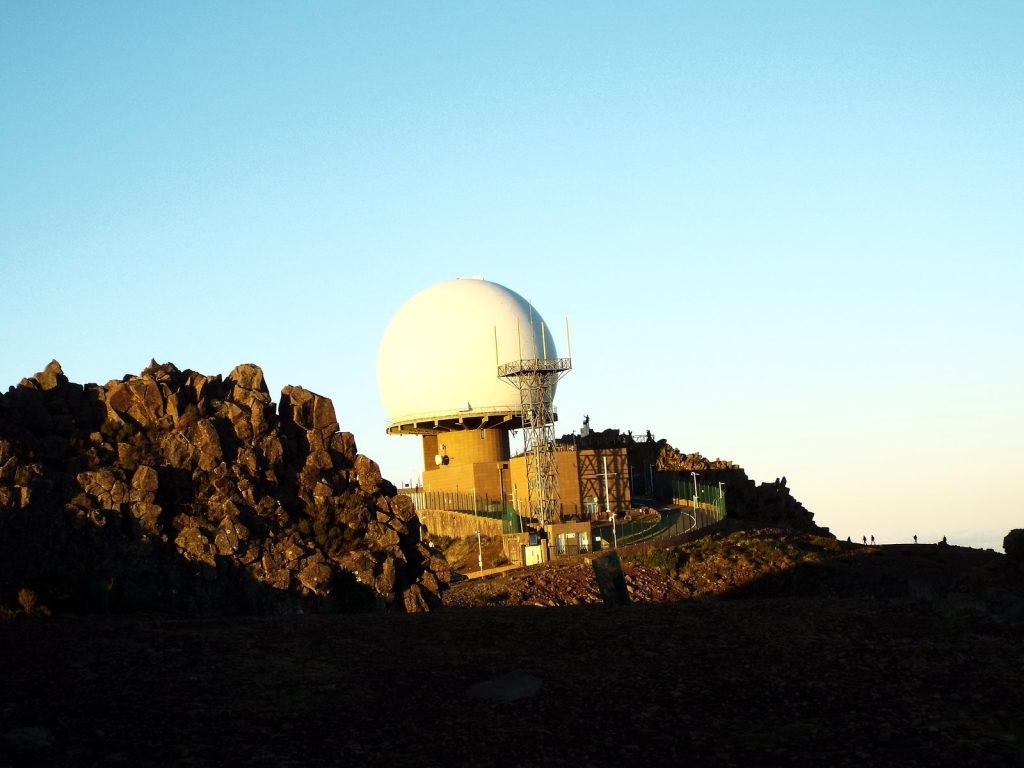 Die weiße Radarkuppel auf dem Gipfel des Pico do Arieiro und zerklüftete Felsen in der Morgensonne