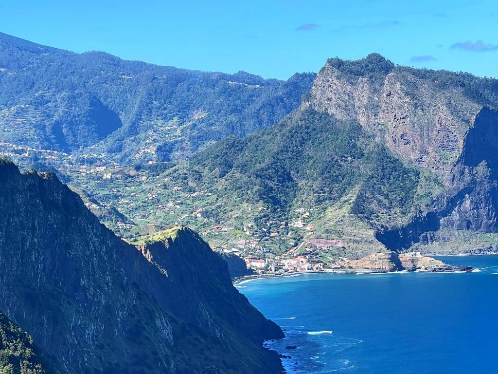 Steile Klippen an Madeiras Nordküste, in der Ferne der Penha d’Águia und Porto da Cruz